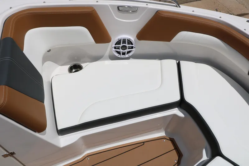 Slide: The Image of 2025 Chaparral 23 SSi boat interior with brown and white seating, cup holder, and speaker. - 45