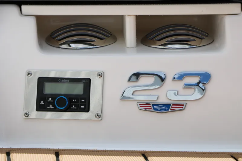 Slide: The Image of 2025 Chaparral 23 SSi boat dashboard with Clarion audio system and chrome detailing. - 12