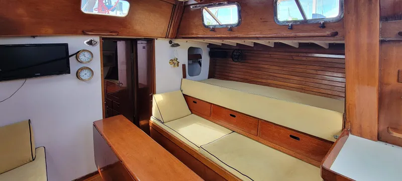 Slide: The Image of Interior of a classic sailboat with wooden features and beige cushions. - 16
