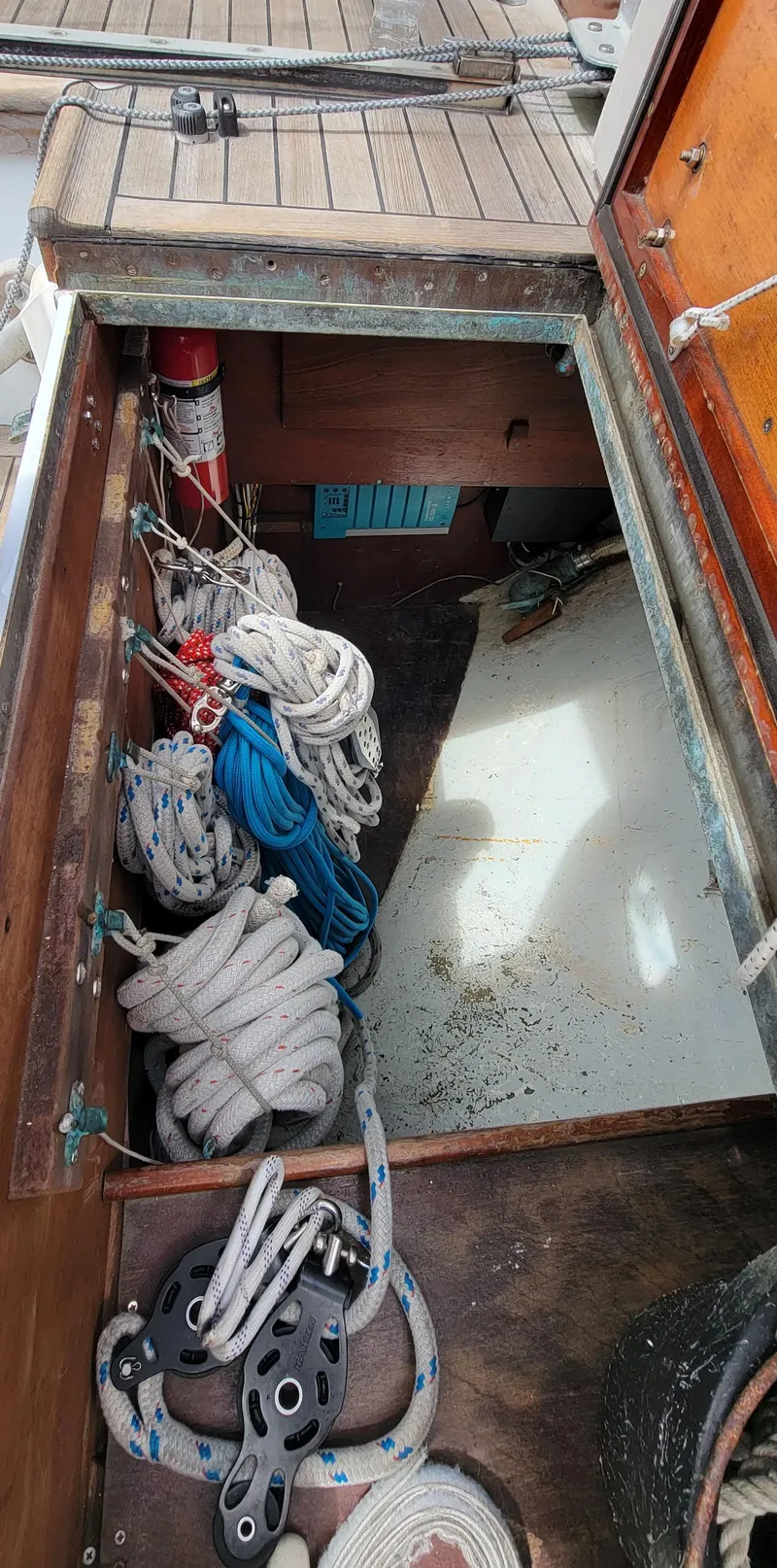Slide: The Image of An open storage compartment on a boat with ropes and a fire extinguisher. - 28