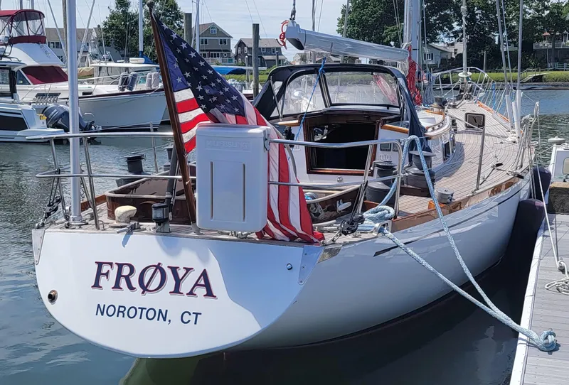 Slide: The Image of A classic sailboat docked, featuring an American flag at the stern. - 5