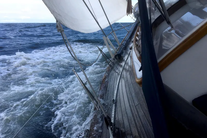 Slide: The Image of Sailboat on rough sea with foaming waves and taut sails. - 33