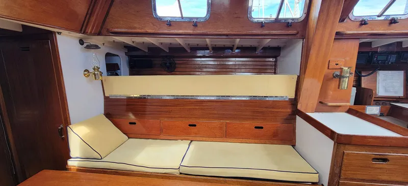 Slide: The Image of Interior of a classic sailboat with wooden features and yellow cushions. - 17