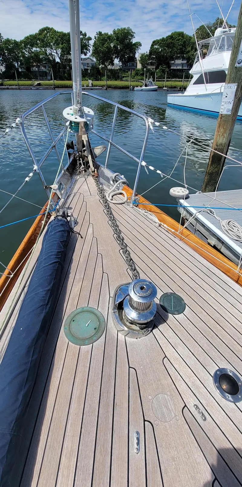 Slide: The Image of Sailboat deck with winches and anchor chain, docked by the water. - 10