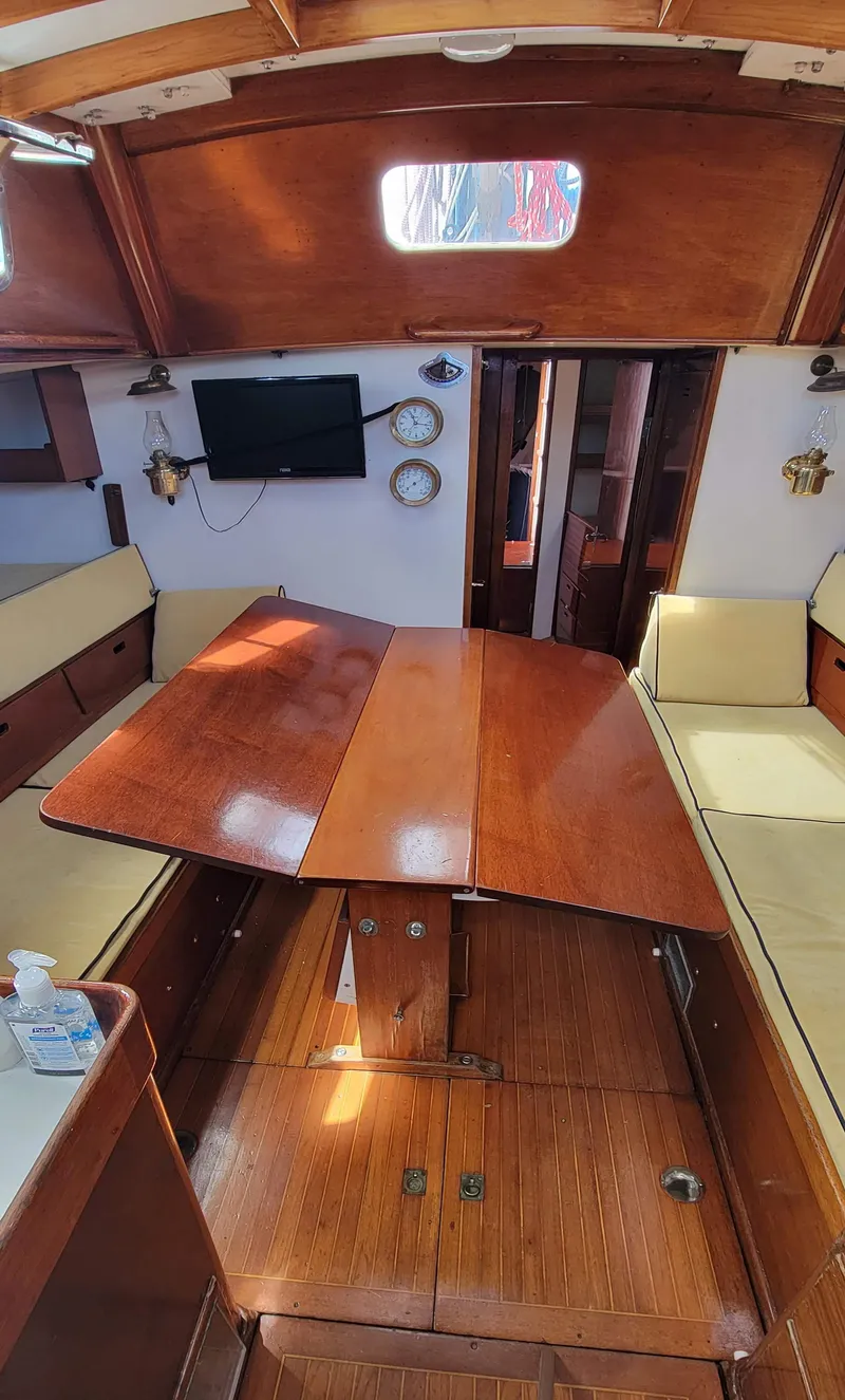 Slide: The Image of Interior of a classic sailboat with wooden table, benches, and navigation instruments. - 15