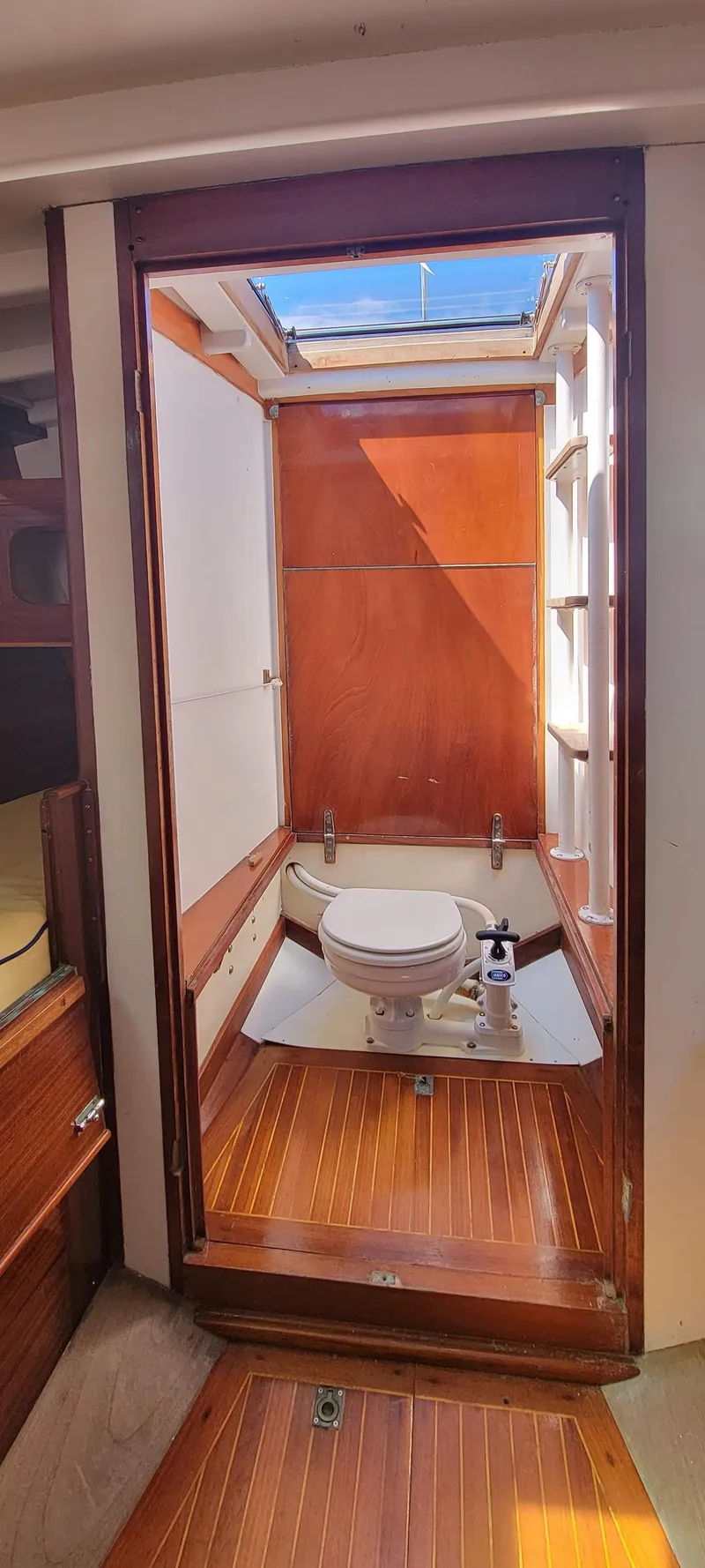 Slide: The Image of The image shows a boat bathroom with wooden flooring and a skylight. - 20