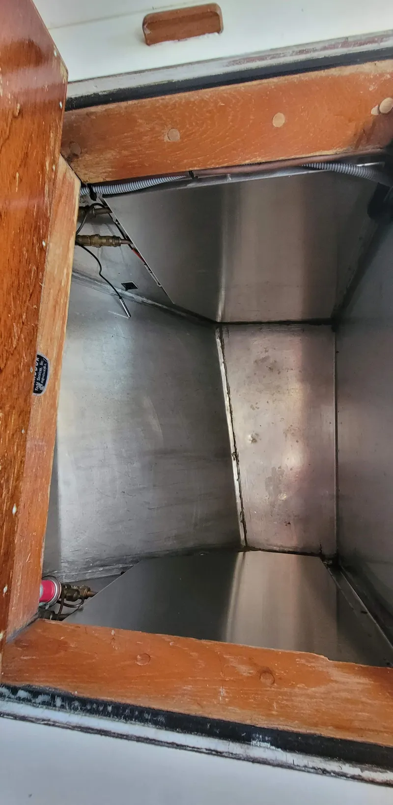 Slide: The Image of Interior view of a boat storage compartment with wooden frame and metal walls. - 26