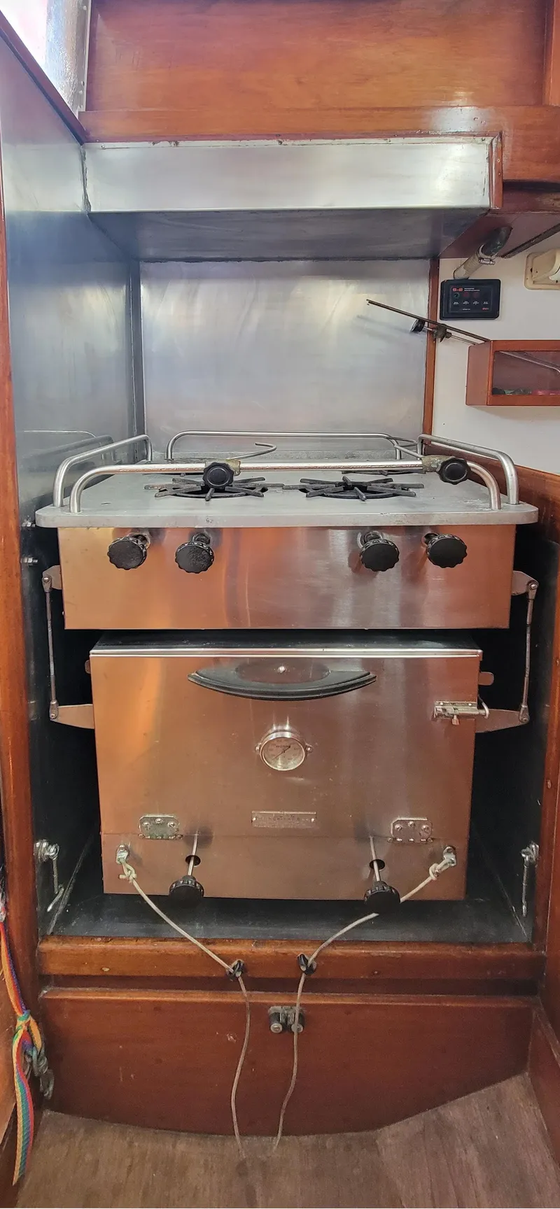 Slide: The Image of A stainless steel stove with oven in a wooden kitchen on a boat. - 24