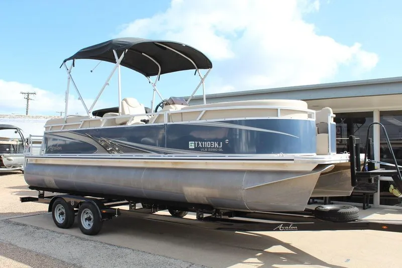 The Image of 2021 Avalon VLS Quad Lounge 22 FT pontoon boat on trailer, featuring a sleek design. - 1