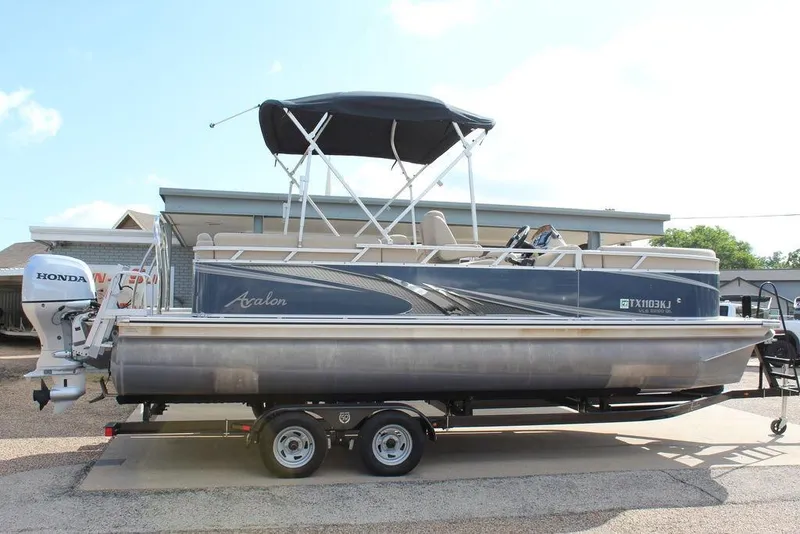 Slide: The Image of 2021 Avalon VLS Quad Lounge 22 FT pontoon boat with Honda outboard motor. - 3