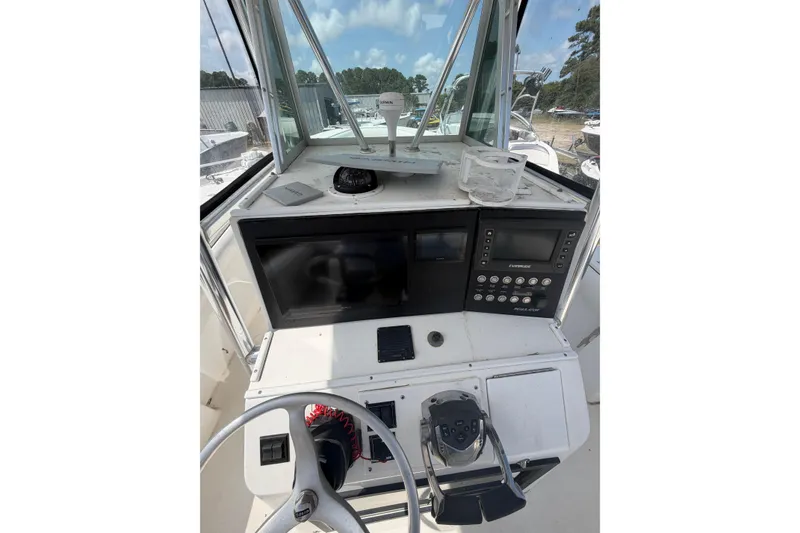 Slide: The Image of Helm of 2000 Regulator 26 Forward Seating boat with navigation instruments and steering wheel. - 8