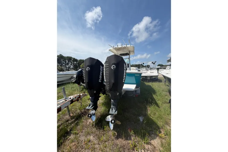 Slide: The Image of 2000 Regulator 26 Forward Seating boat with twin Evinrude engines on grassy lot. - 3