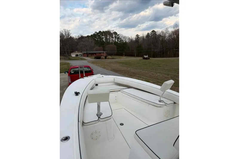 Slide: The Image of 2000 Regulator 26 Forward Seating boat on trailer, parked in a rural driveway. - 10