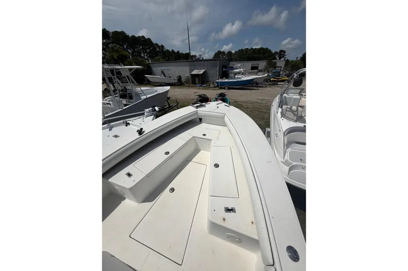 Slide: The Image of 2000 Regulator 26 Forward Seating boat with spacious deck, docked outdoors. - 12