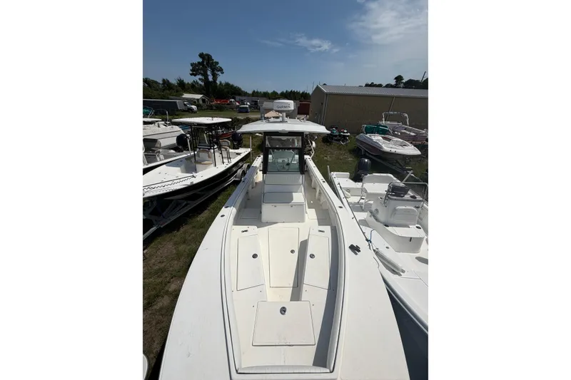 Slide: The Image of 2000 Regulator 26 Forward Seating boat in a marina, surrounded by other vessels. - 11