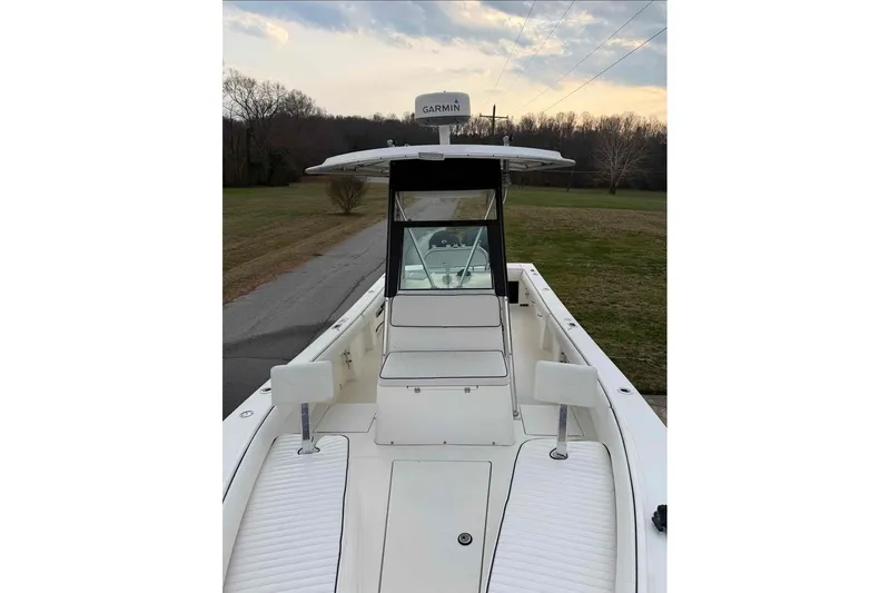 Slide: The Image of 2000 Regulator 26 Forward Seating boat with Garmin equipment, docked on a scenic road. - 9