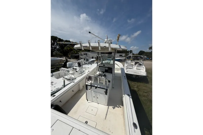 Slide: The Image of 2000 Regulator 26 Forward Seating boat with center console, parked outdoors under a blue sky. - 5