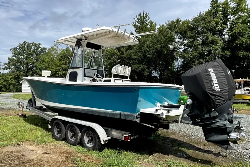 Slide: The Image of A 2000 Regulator 26 Forward Seating boat on a trailer, surrounded by trees. - 17
