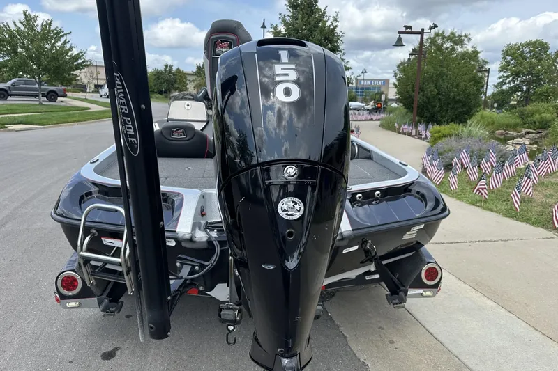 Slide: The Image of 2018 Ranger Z518 boat with 150 HP engine, parked on a street with American flags. - 8