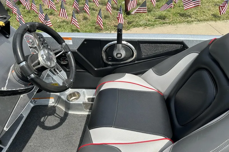 Slide: The Image of 2018 Ranger Z518 boat interior with steering wheel, seat, and American flags in background. - 20