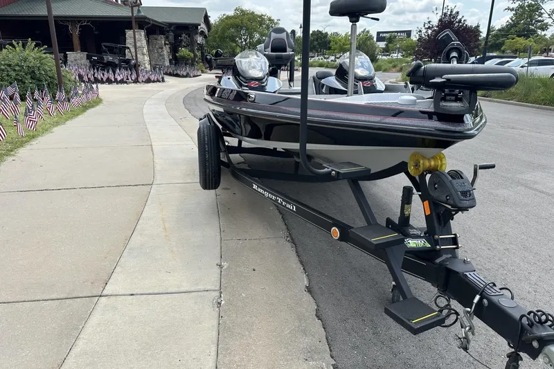 Slide: The Image of 2018 Ranger Z518 boat on trailer, parked on roadside near American flags. - 14