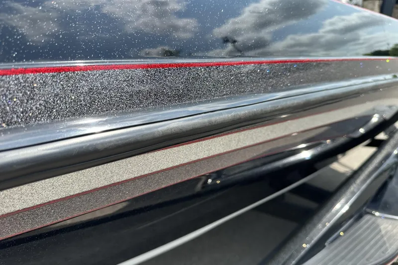 Slide: The Image of Close-up of 2018 Ranger Z518 boat with metallic finish and red accents under a cloudy sky. - 3