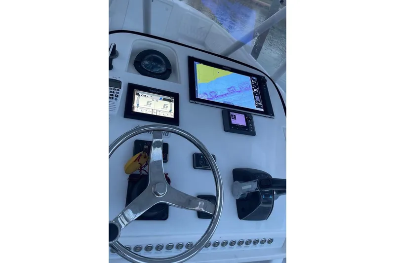 Slide: The Image of Helm of 2002 Intrepid 323 Cuddy with navigation screens and steering wheel. - 16