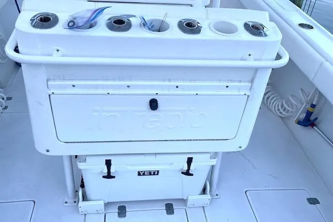 Slide: The Image of 2002 Intrepid 323 Cuddy boat deck with fishing rod holders and Yeti cooler. - 8