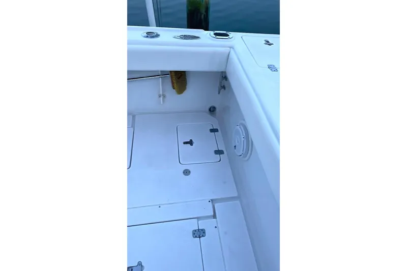 Slide: The Image of 2002 Intrepid 323 Cuddy boat deck with storage compartments and clean white surface. - 6