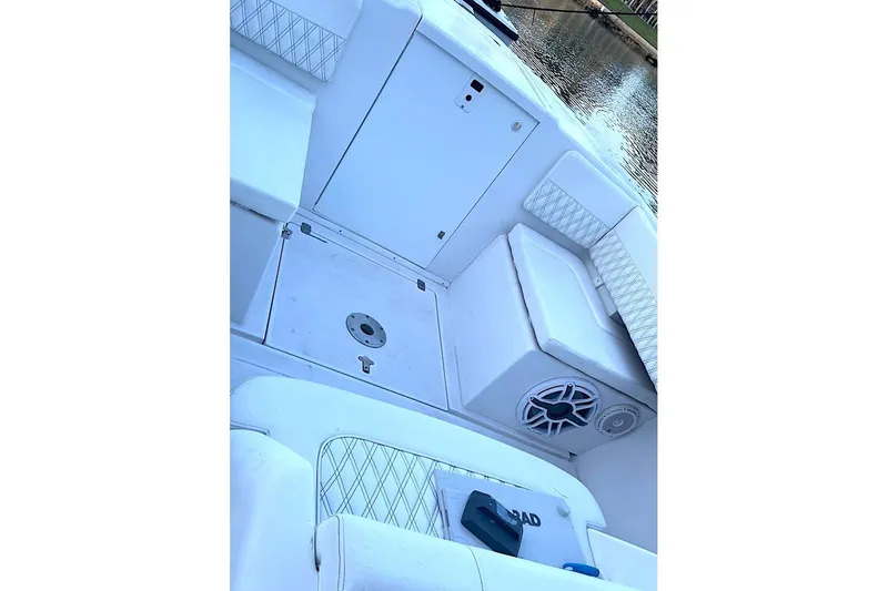 Slide: The Image of 2002 Intrepid 323 Cuddy boat interior with white seating and speaker system. - 11