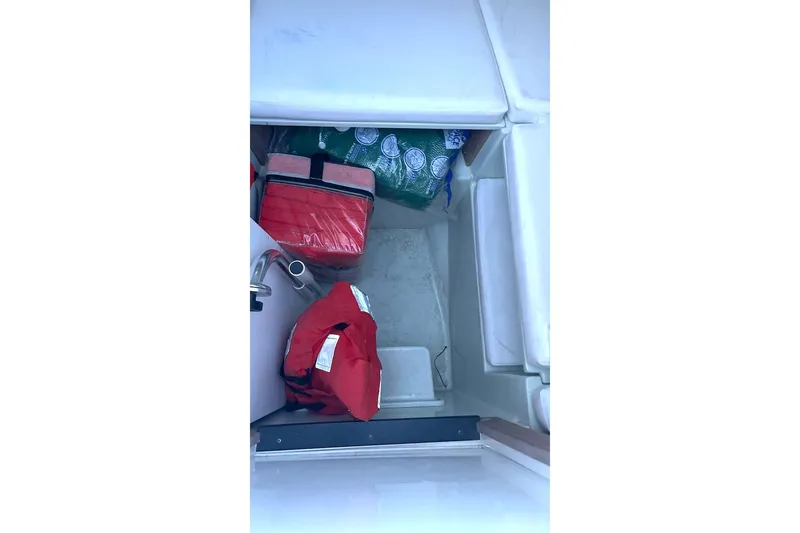 Slide: The Image of Storage compartment in a 2002 Intrepid 323 Cuddy boat with life jackets and supplies. - 9