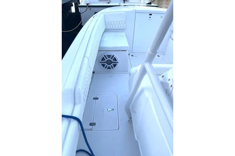Slide: The Image of 2002 Intrepid 323 Cuddy boat interior with white seating and storage compartments. - 14