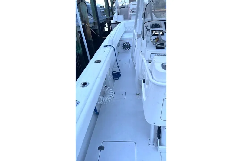 Slide: The Image of 2002 Intrepid 323 Cuddy boat interior with white deck and seating area. - 13