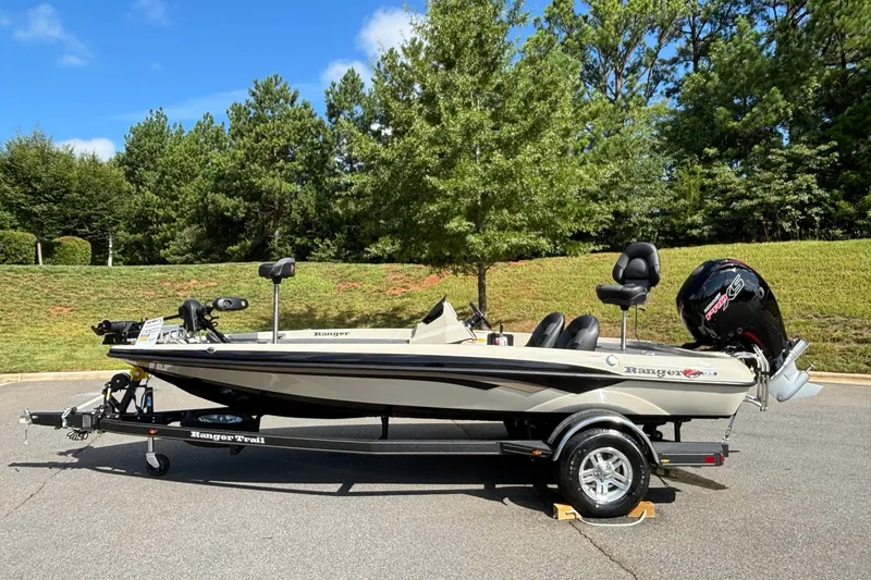 The Image of 2026 Ranger Z185 boat on trailer, parked outdoors with lush green trees in the background. - 0