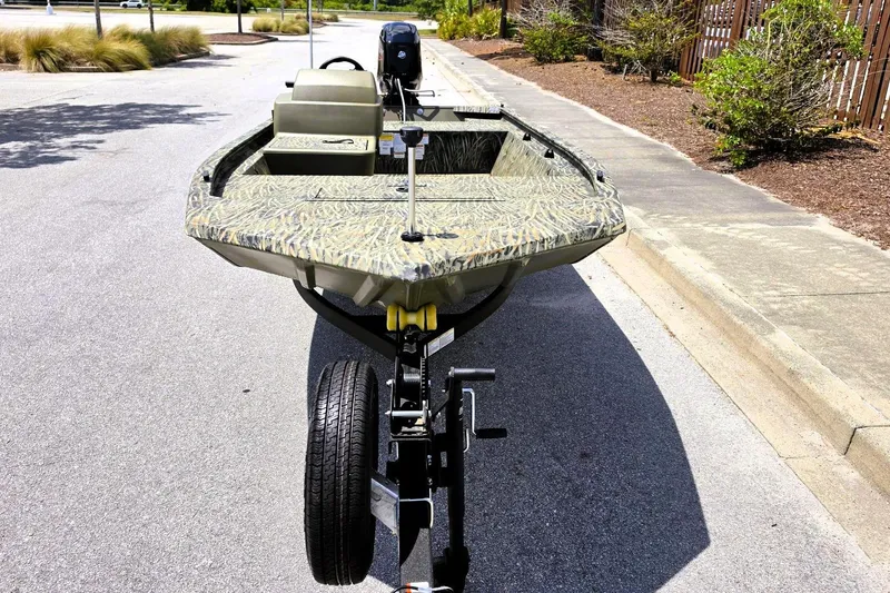 Slide: The Image of 2026 Tracker Grizzly 1648 SC boat on trailer, parked on a sunny street. - 8