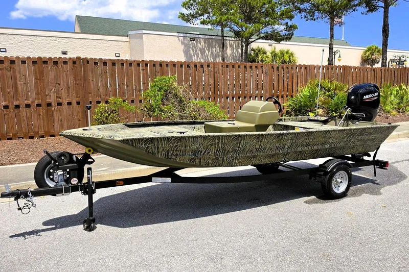 Slide: The Image of 2026 Tracker Grizzly 1648 SC boat on trailer, camo design, parked outdoors. - 6