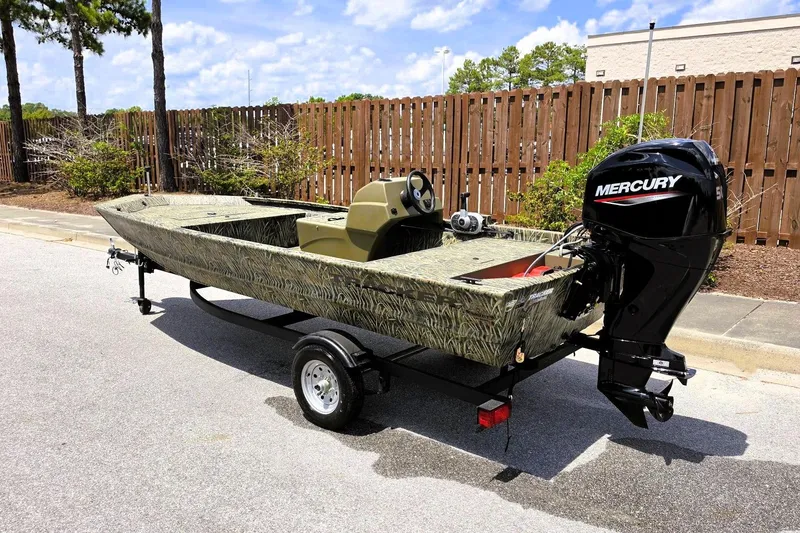 Slide: The Image of 2026 Tracker Grizzly 1648 SC boat with Mercury engine on trailer, parked outdoors. - 7