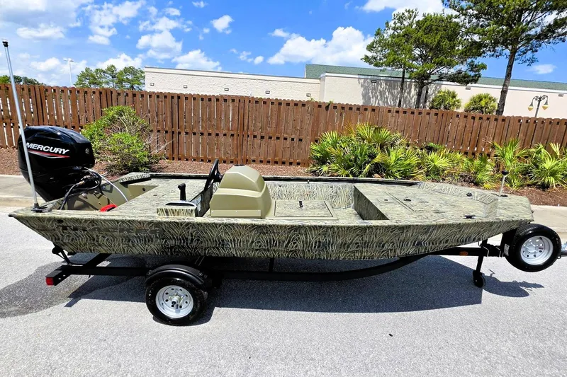 Slide: The Image of 2026 Tracker Grizzly 1648 SC boat with camouflage design and Mercury outboard motor. - 4