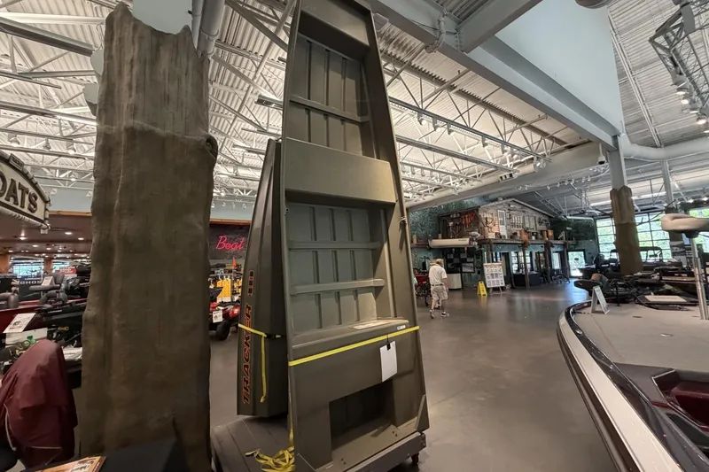 The Image of 2026 Tracker Grizzly 14 Jon boat displayed in a showroom with high ceilings. - 0