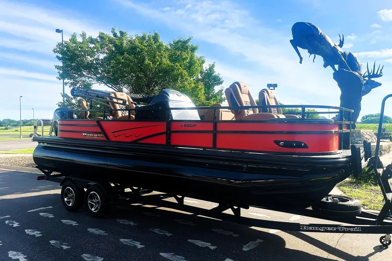 Slide: The Image of 2026 Ranger 220F pontoon boat on trailer, parked outdoors under clear sky. - 8