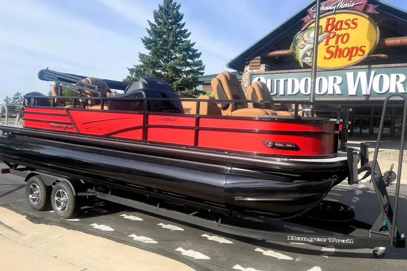Slide: The Image of 2026 Ranger 220F pontoon boat on trailer outside Bass Pro Shops. - 3