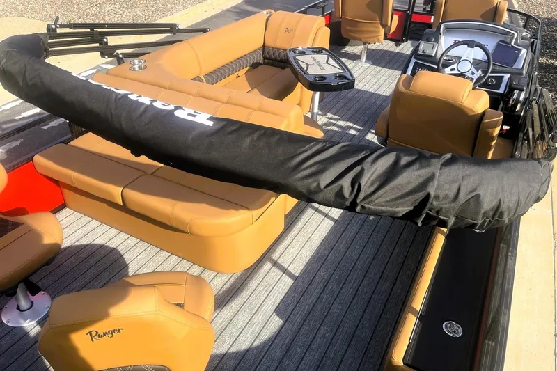 Slide: The Image of 2026 Ranger 220F boat interior with tan seating and covered equipment. - 7
