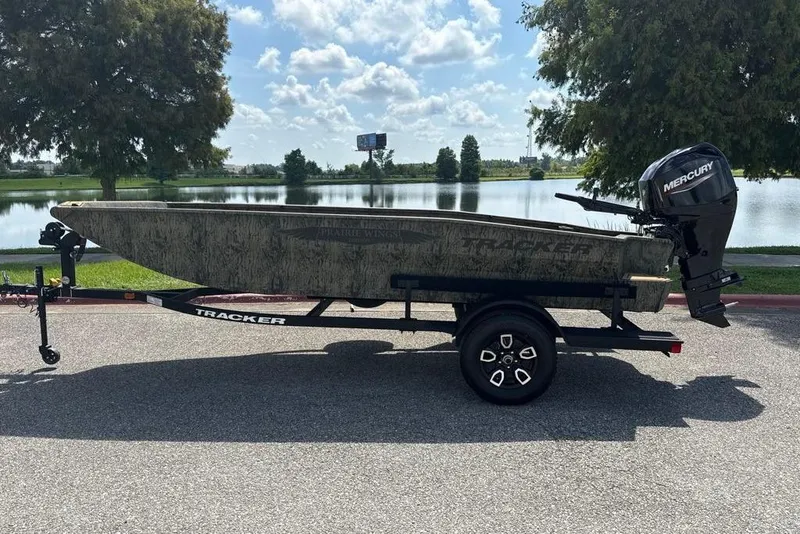 The Image of 2026 Tracker Grizzly 1650 T Prairie Wings Edition boat on trailer by a lake. - 0
