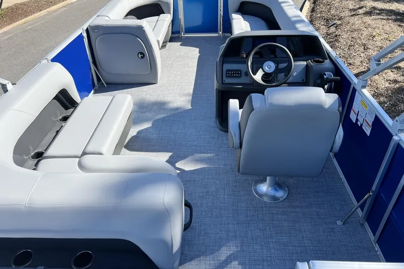 Slide: The Image of 2026 Sun Tracker Party Barge 18 DLX interior with gray seating and steering console. - 3