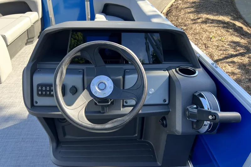 Slide: The Image of 2026 Sun Tracker Party Barge 18 DLX steering console with modern controls and cup holder. - 2