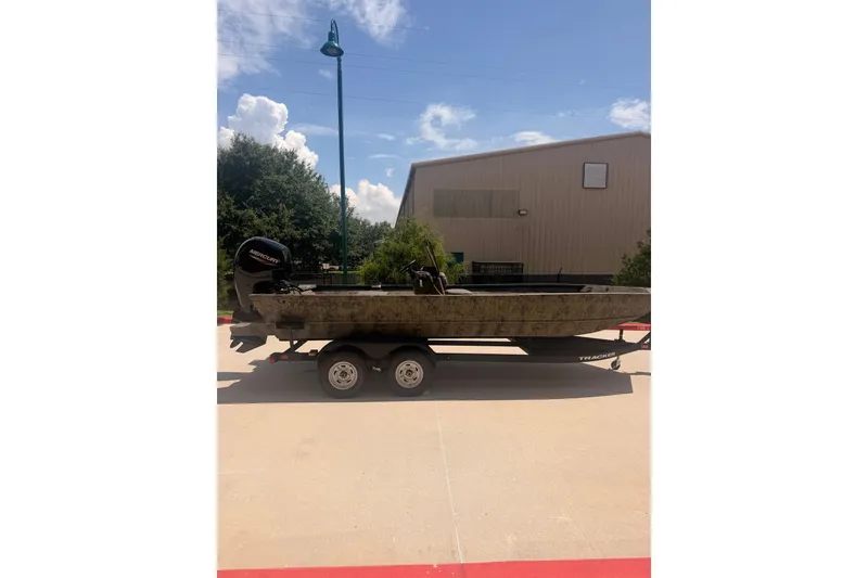 The Image of 2026 Tracker Grizzly 2072 CC boat on trailer, parked outdoors under clear sky. - 0