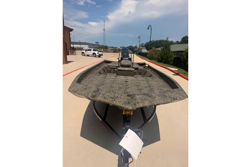 Slide: The Image of 2026 Tracker Grizzly 2072 CC boat on trailer, parked outdoors under a clear sky. - 13