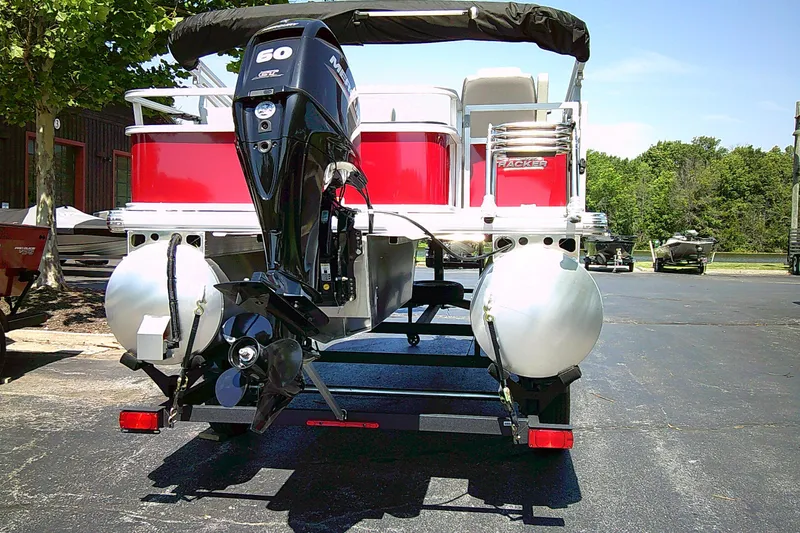 Slide: The Image of 2026 Sun Tracker Bass Buggy 18 DLX pontoon boat with Mercury 60 HP engine, parked outdoors. - 5