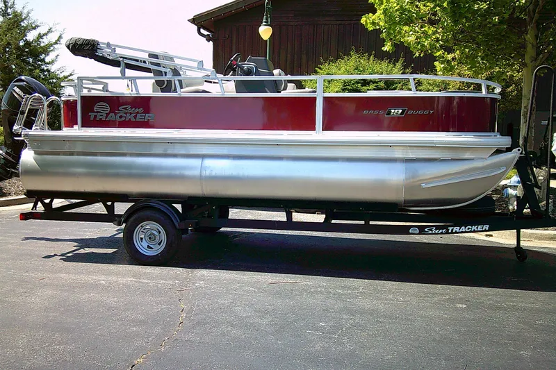The Image of 2026 Sun Tracker Bass Buggy 18 DLX pontoon boat on trailer, parked outdoors. - 0