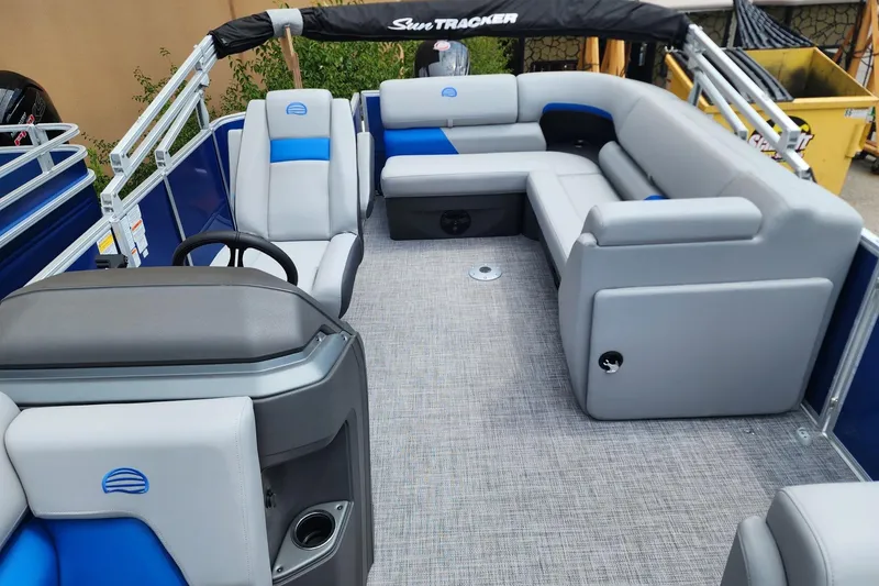 Slide: The Image of 2026 Sun Tracker Party Barge 20 DLX interior with gray and blue seating, spacious layout. - 2